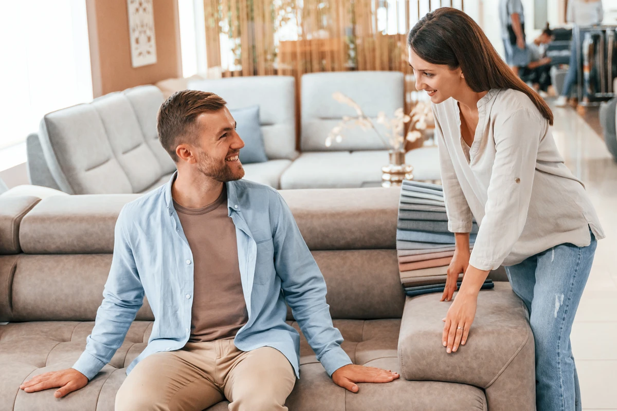 Couple inspecting sofa in furniture store.