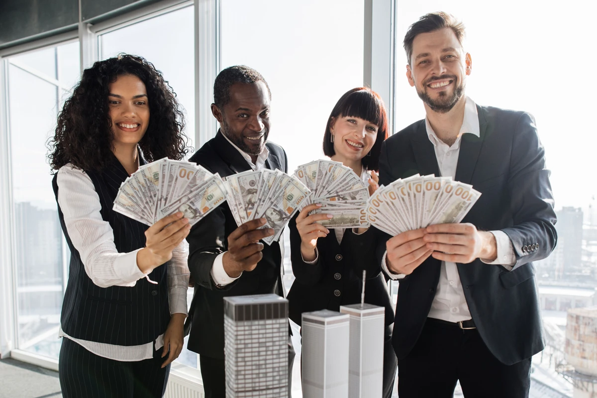 Group of professionals holding money in office.