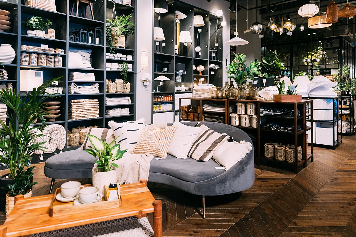 Modern home decor store with plants and pillows.