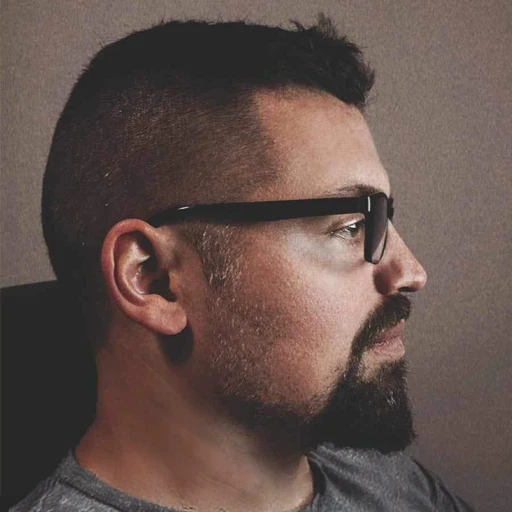 Profile of bearded man with glasses looking right