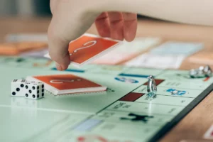 Hand placing a card on a board game