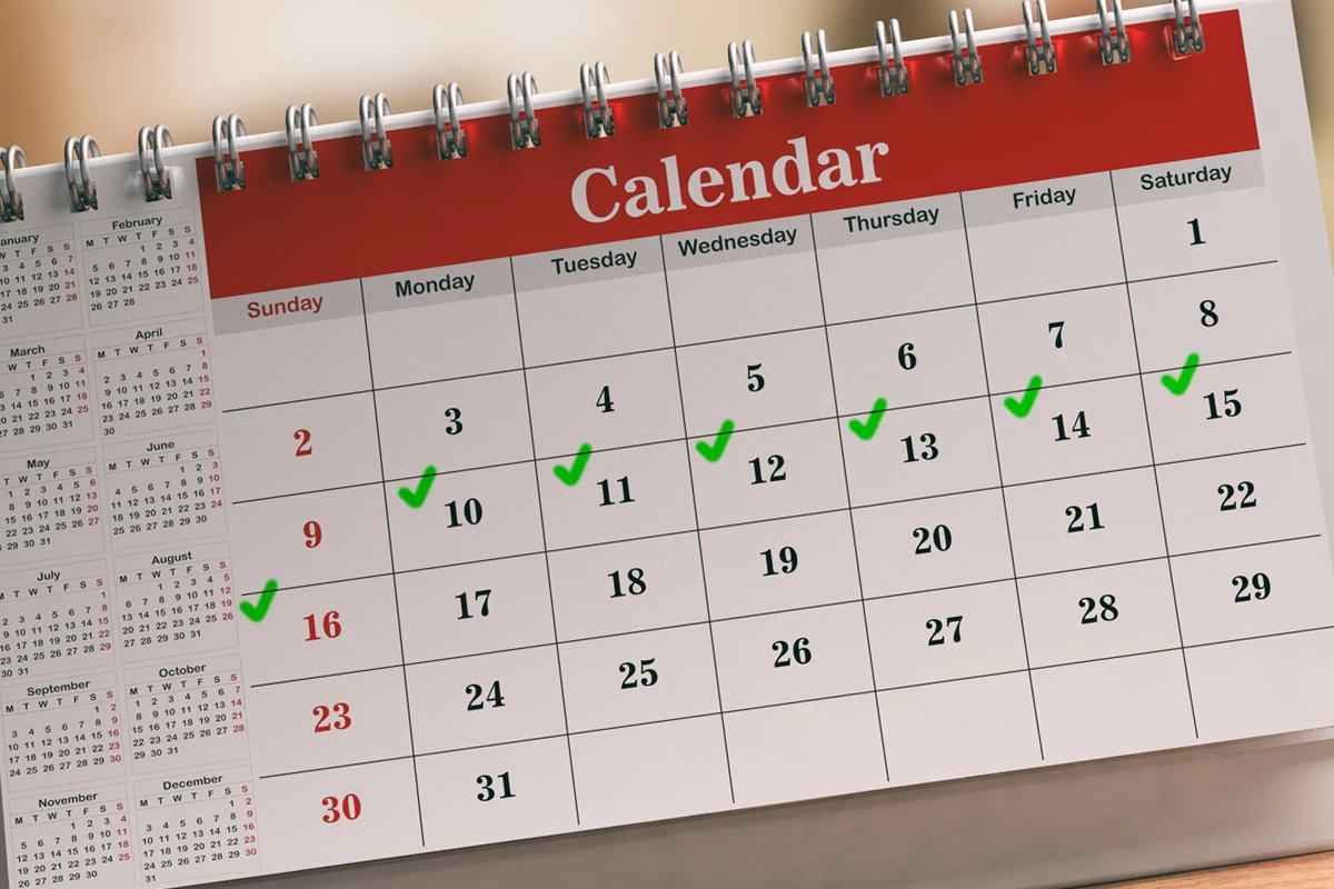 Desk calendar with green check marks on various dates