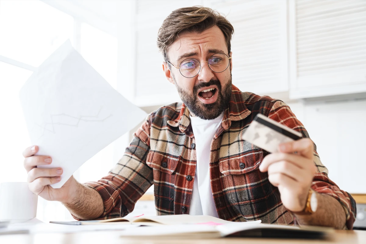 Stressed man with documents and credit card