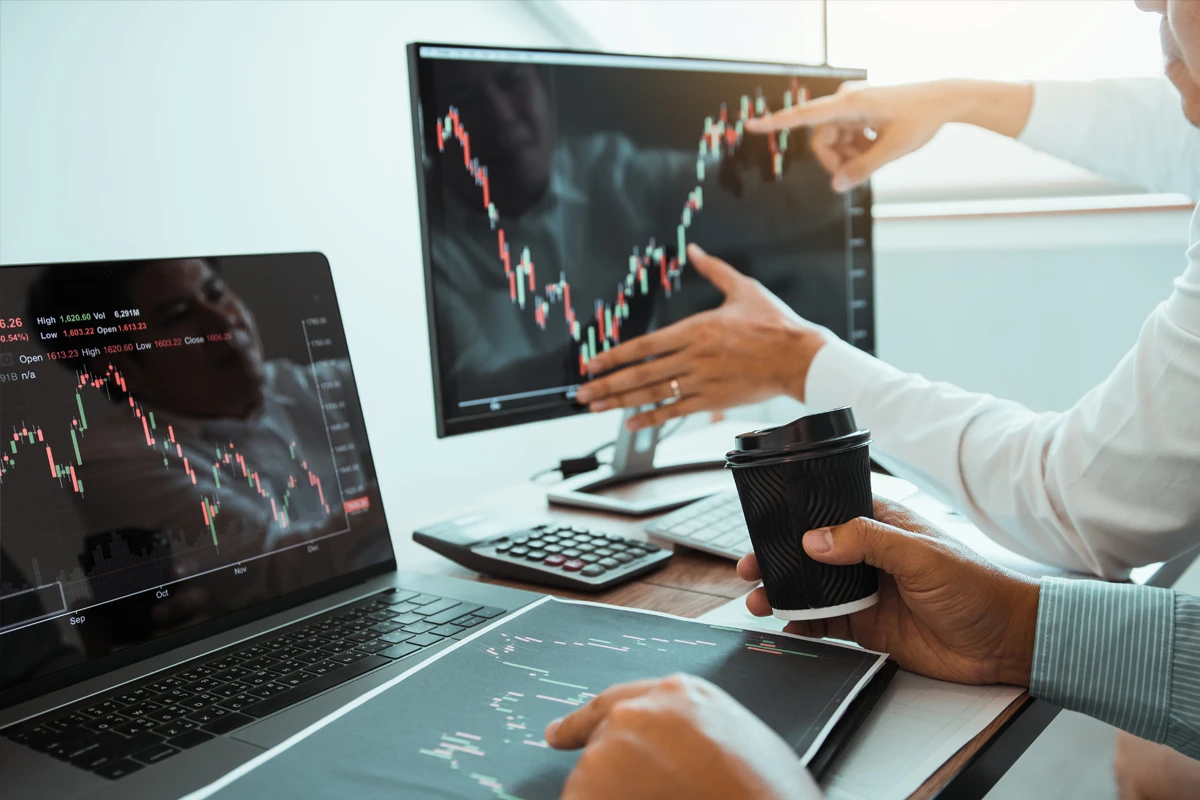 Professionals analyzing financial charts on computer screens