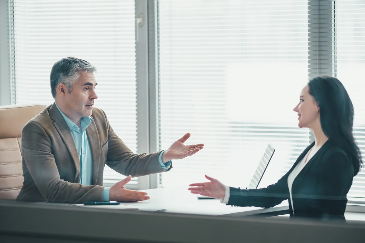 Business meeting discussion between man and woman in office.