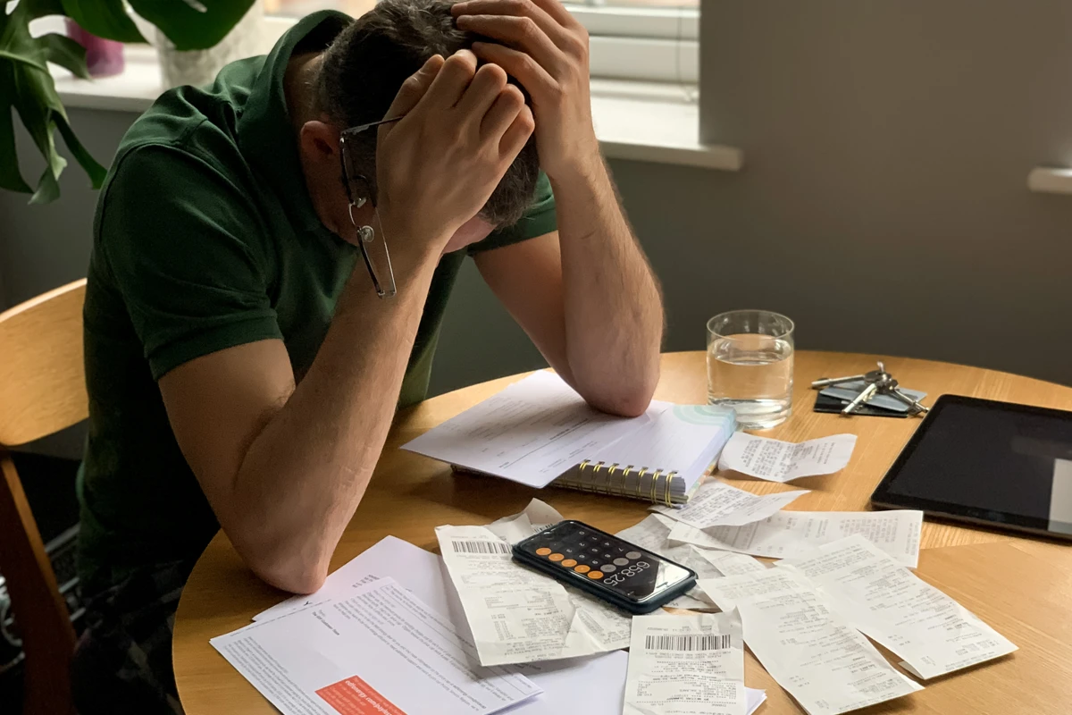 Man stressed over paperwork and bills at desk