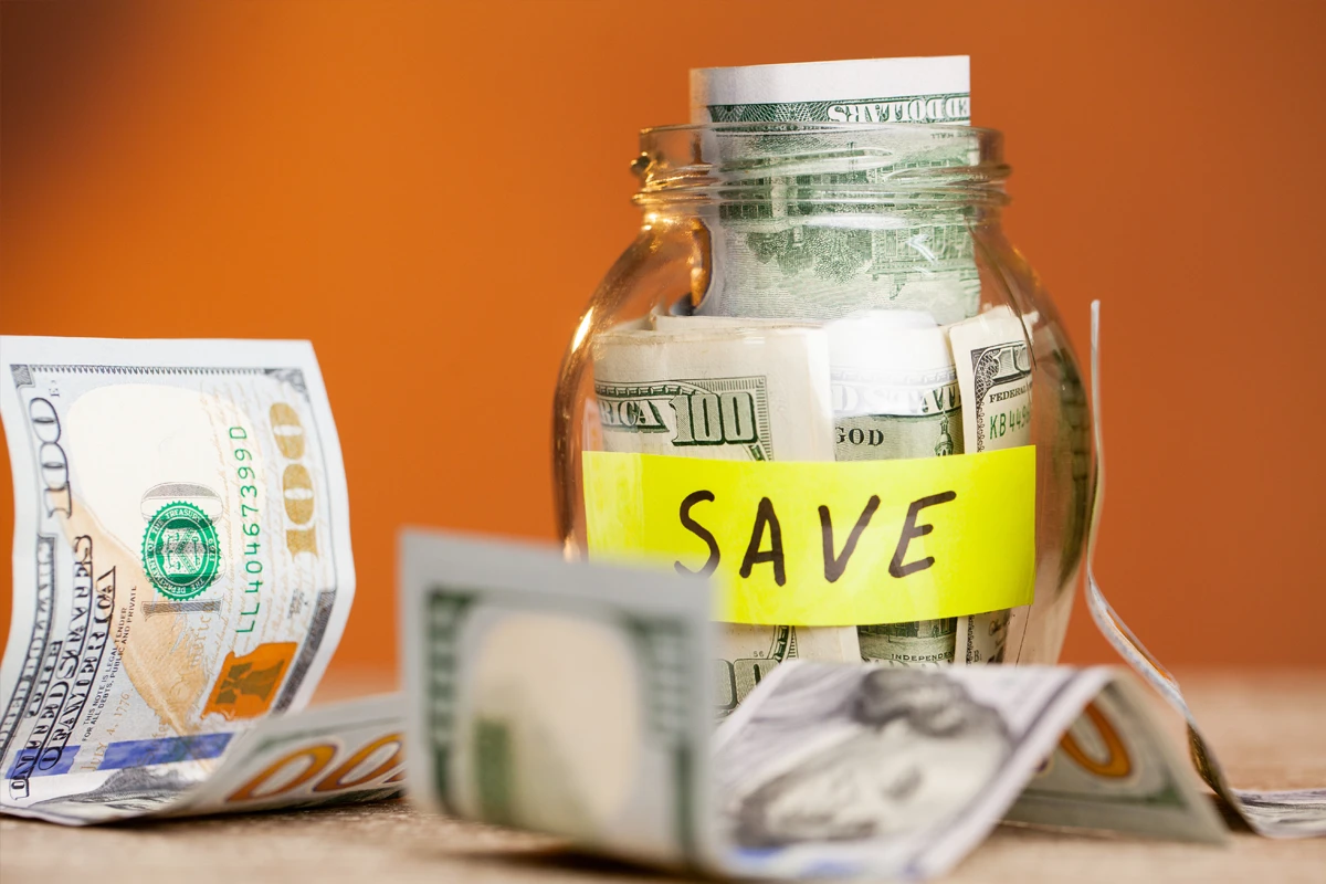 Save money concept with dollars in glass jar