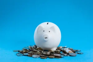 White piggy bank on coins, blue background