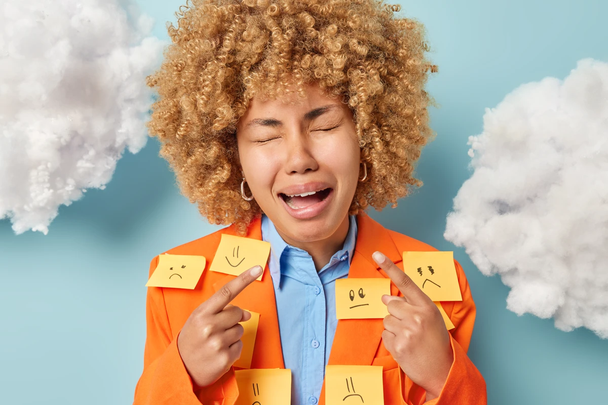 Woman with emotion stickers pointing at clouds