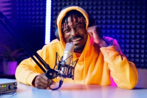 Smiling man in yellow hoodie recording podcast