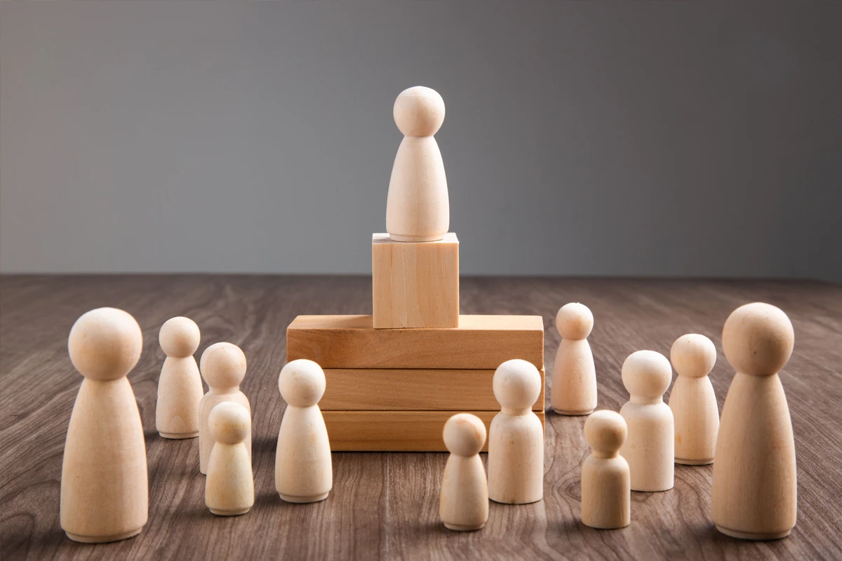 Wooden figures symbolizing leadership and team organization