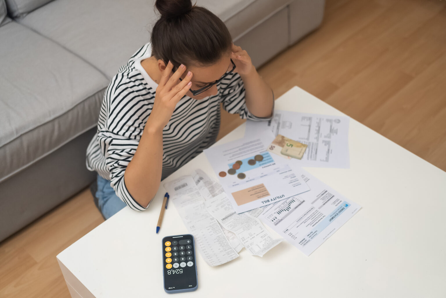 Woman stressed sorting bills and documents on table
