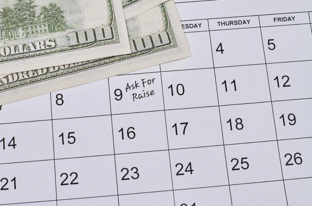 Calendar marked 'Ask For Raise' with $100 bills