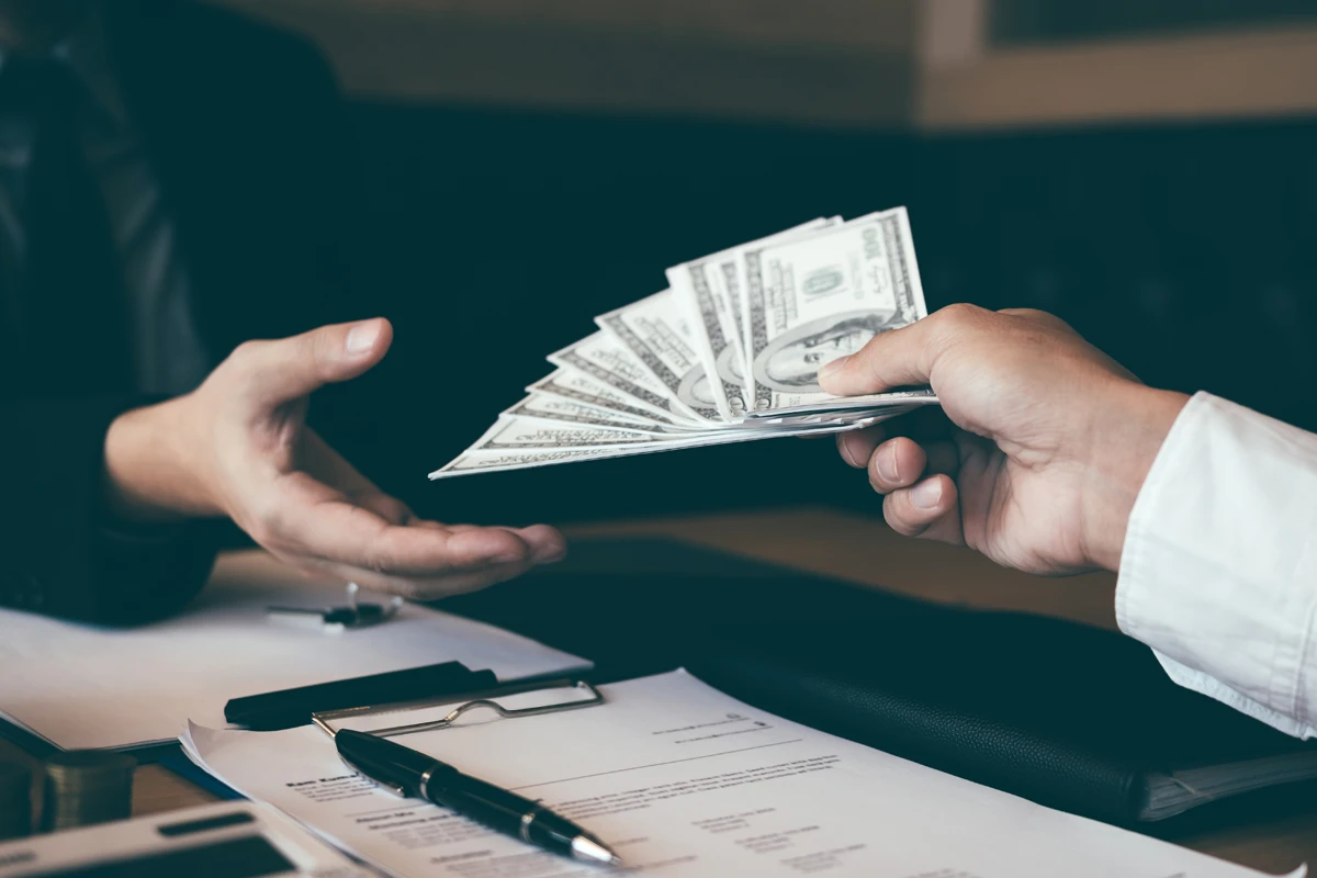 Person handing over cash in business setting