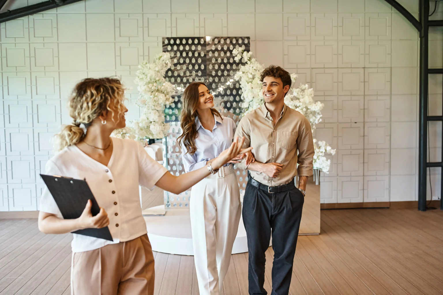Wedding planner greeting couple in decorated venue