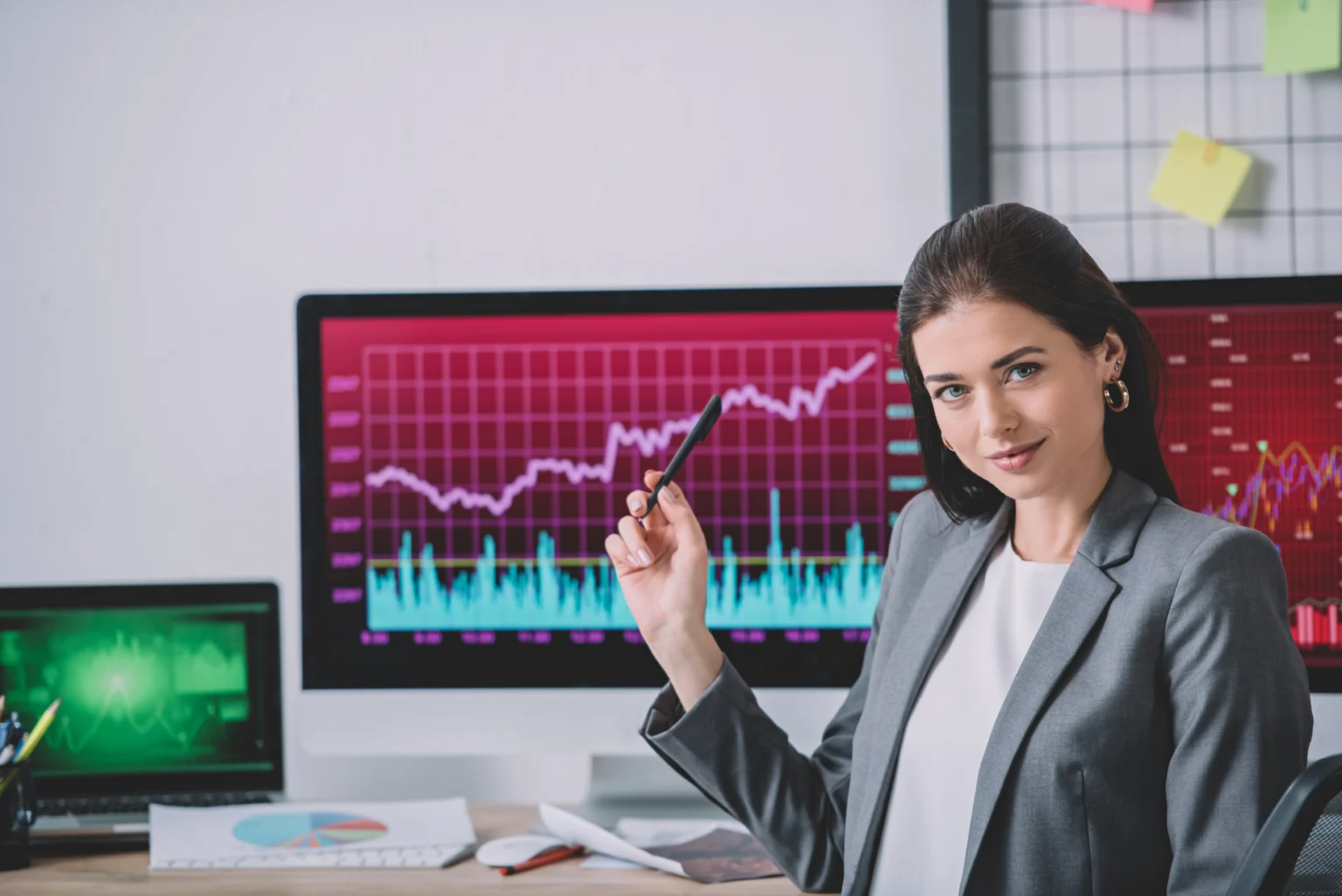 Businesswoman analyzing financial data on computer screens