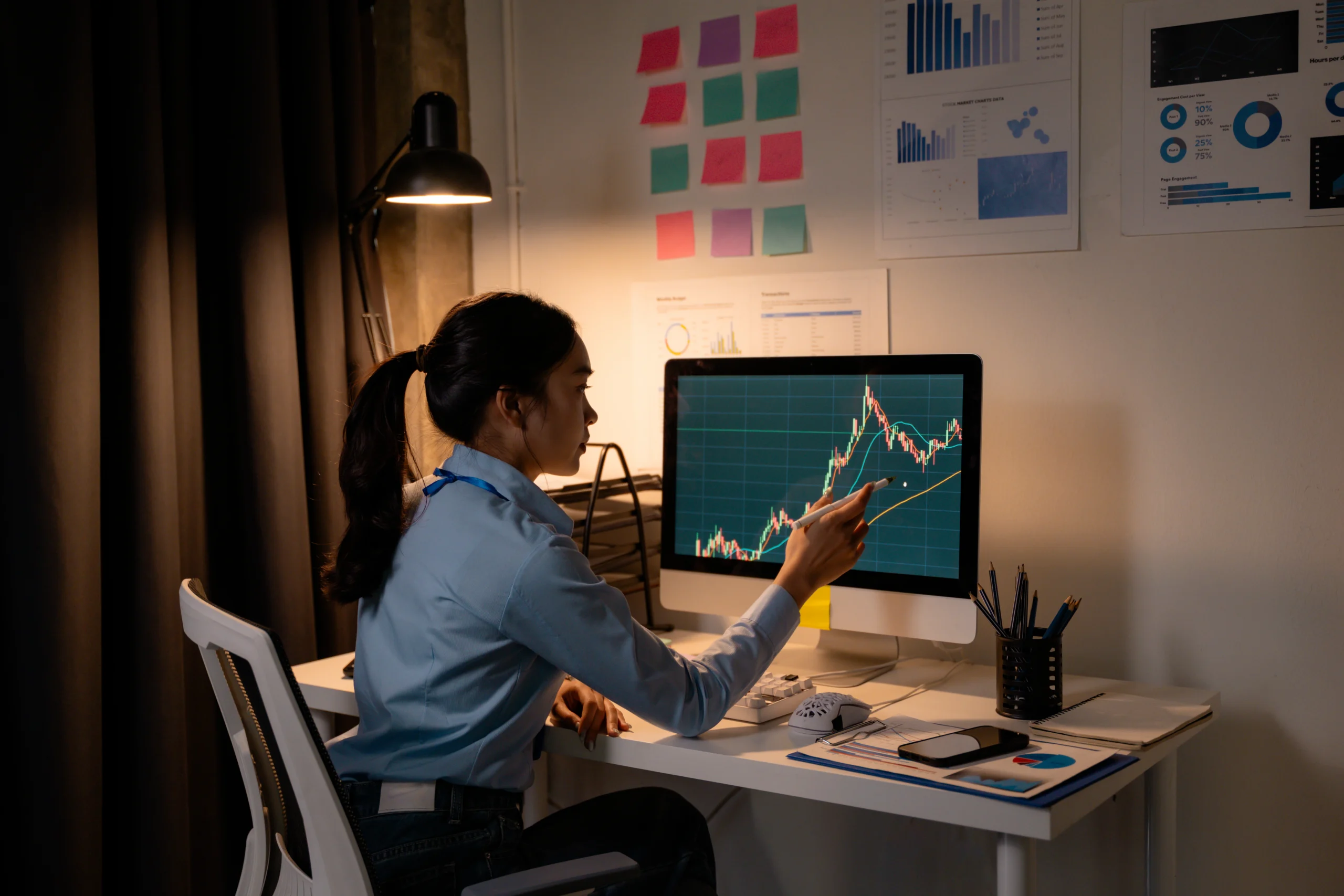 Woman analyzing financial charts on computer screen