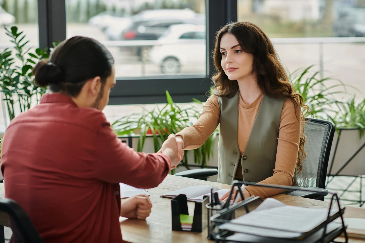 Two women shaking hands in office, business meeting