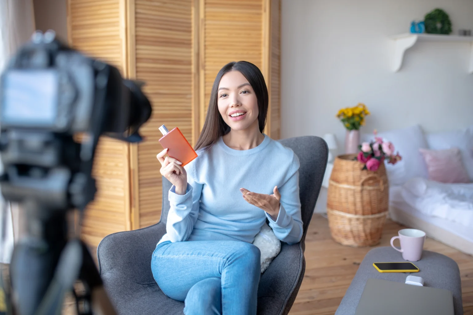 Woman vlogging about perfumes from cozy home setup