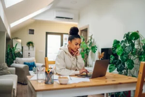 Woman working on laptop in bright home office