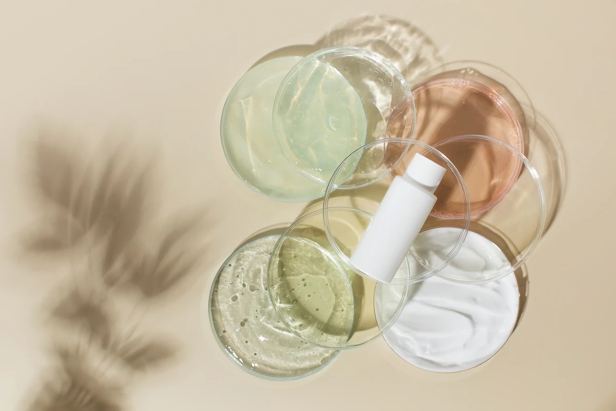 Assorted skincare creams and serums in petri dishes