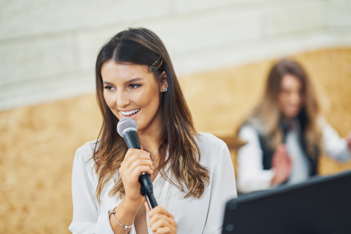 Woman with microphone speaking at event
