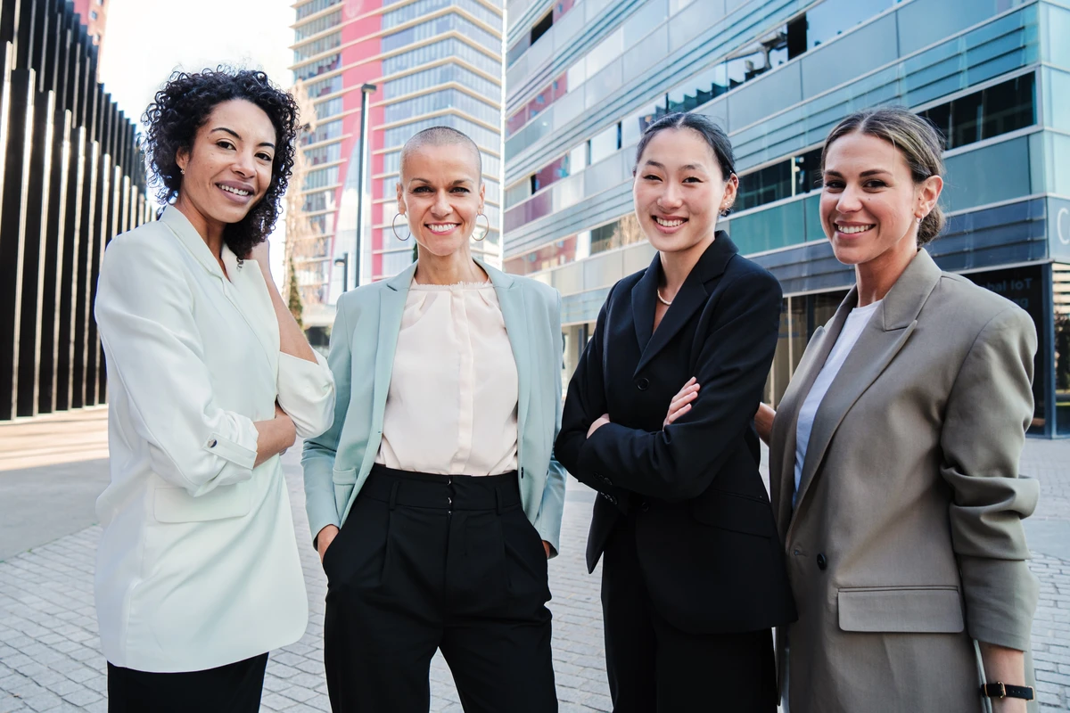 Four professional women smiling in urban setting