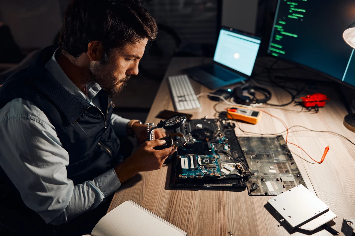 Engineer repairing computer motherboard at electronics workshop
