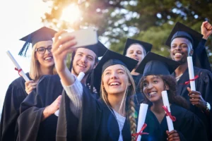 Graduates taking selfie with diplomas at commencement
