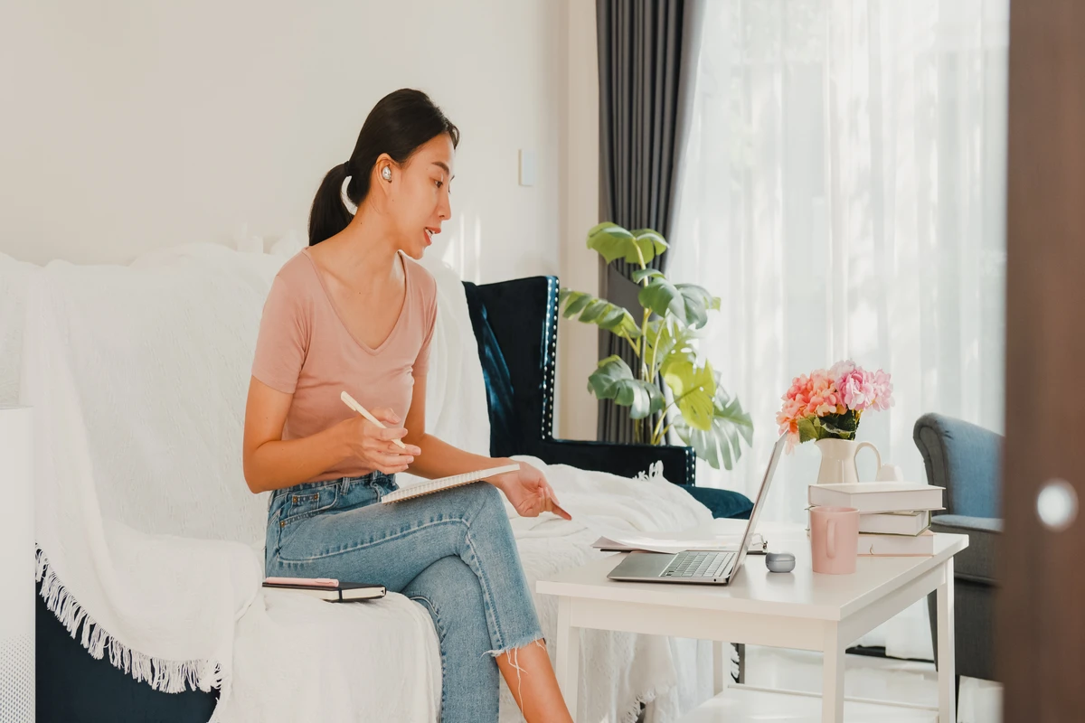 Young woman telecommuting from cozy home office