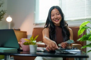 Smiling woman organizing finances at home office desk