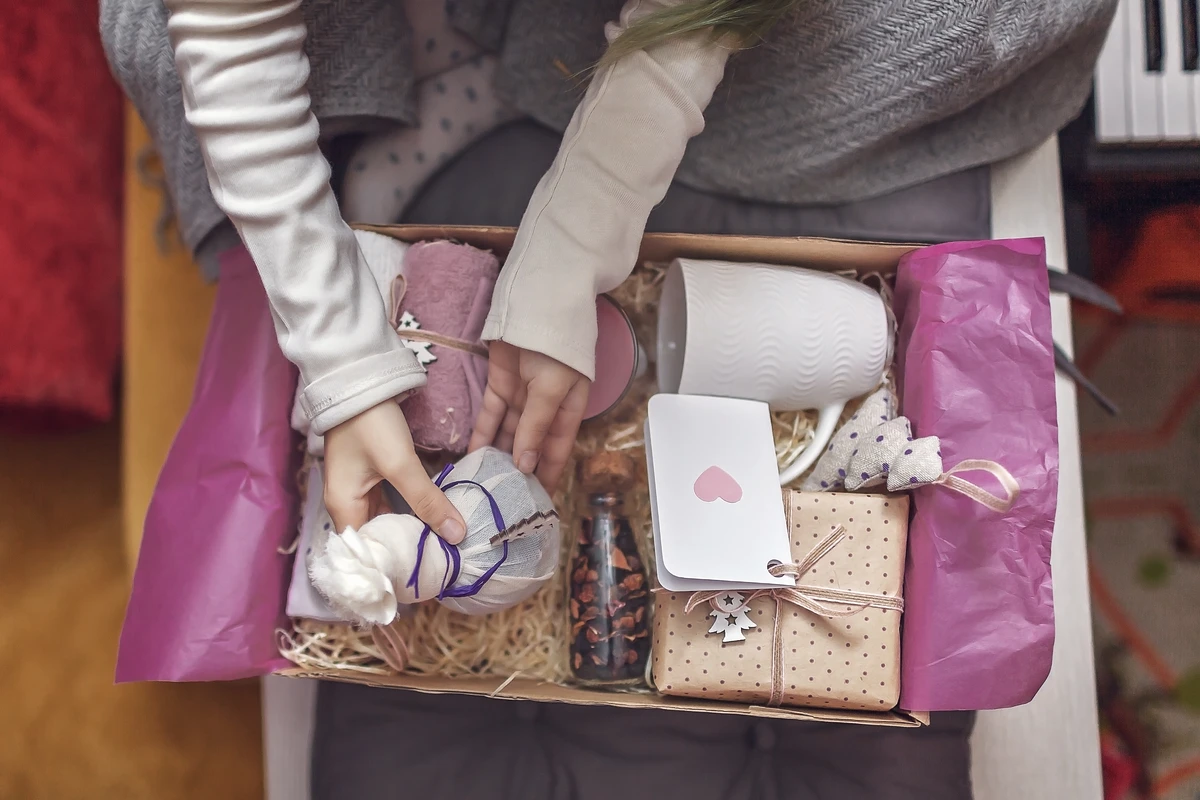 Person holding gift box with assorted presents