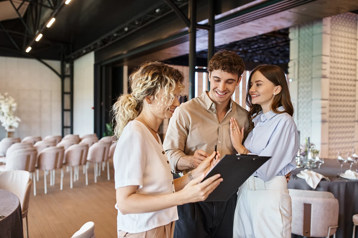 Couple planning wedding with coordinator in venue