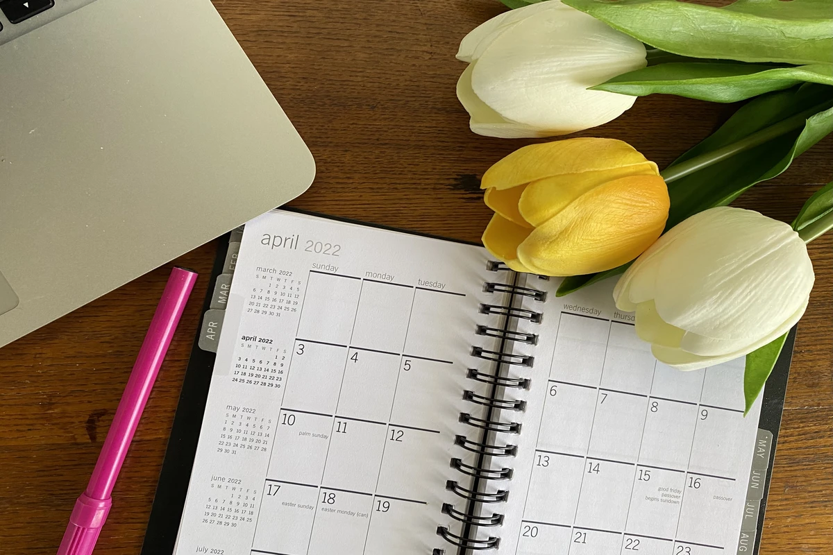 April 2022 calendar with tulips and laptop on desk