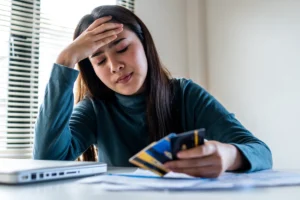 Woman stressed over finances holding credit cards