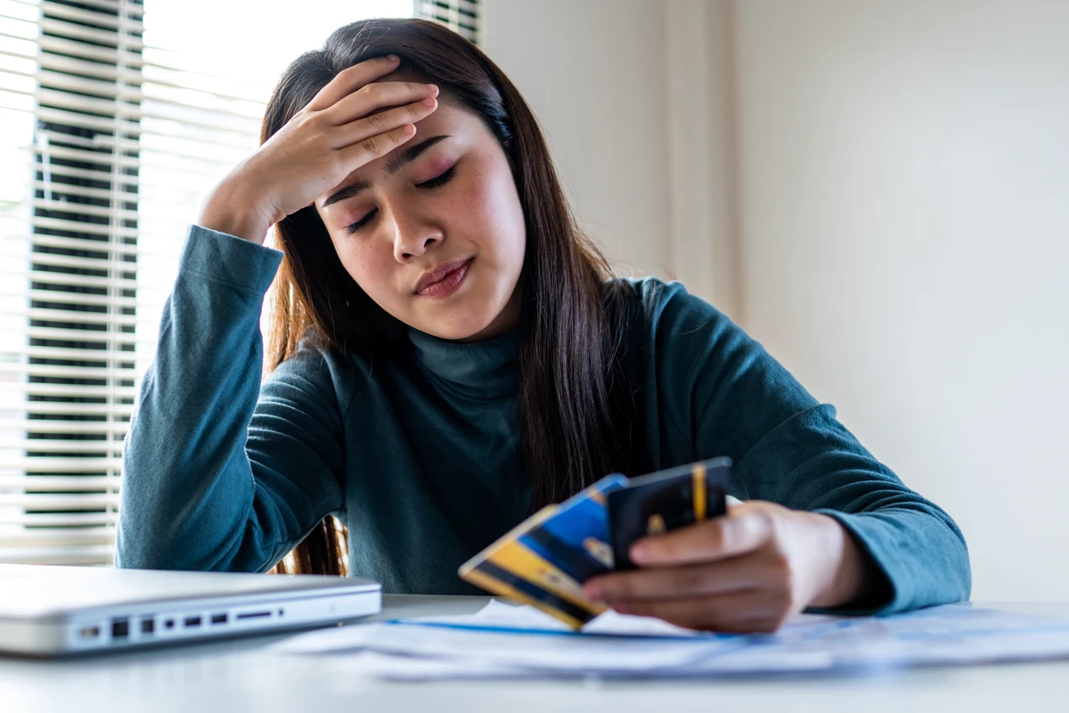 Woman stressed over finances holding credit cards