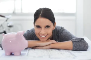 a woman leaning on a piggy bank