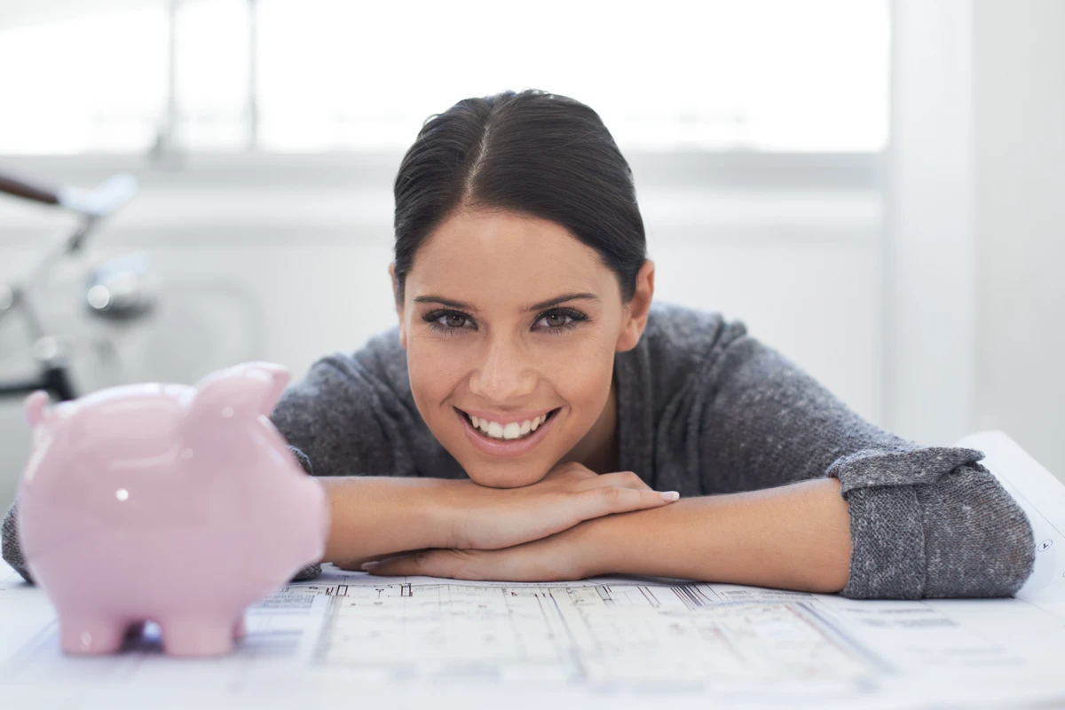 a woman leaning on a piggy bank