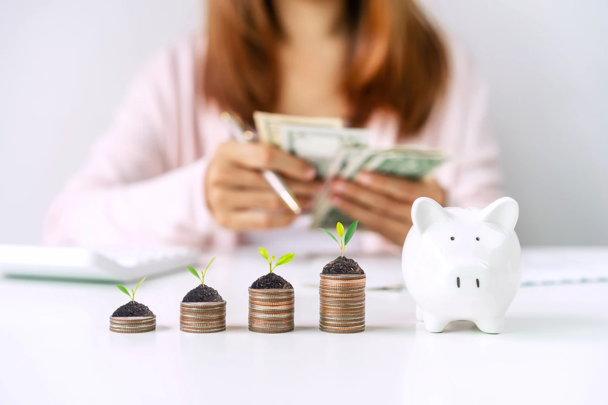 a piggy bank with coins and a piggy bank with a woman counting money