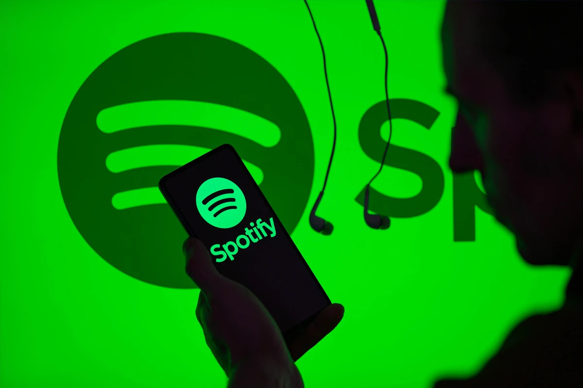 a person holding a phone with a logo on the screen