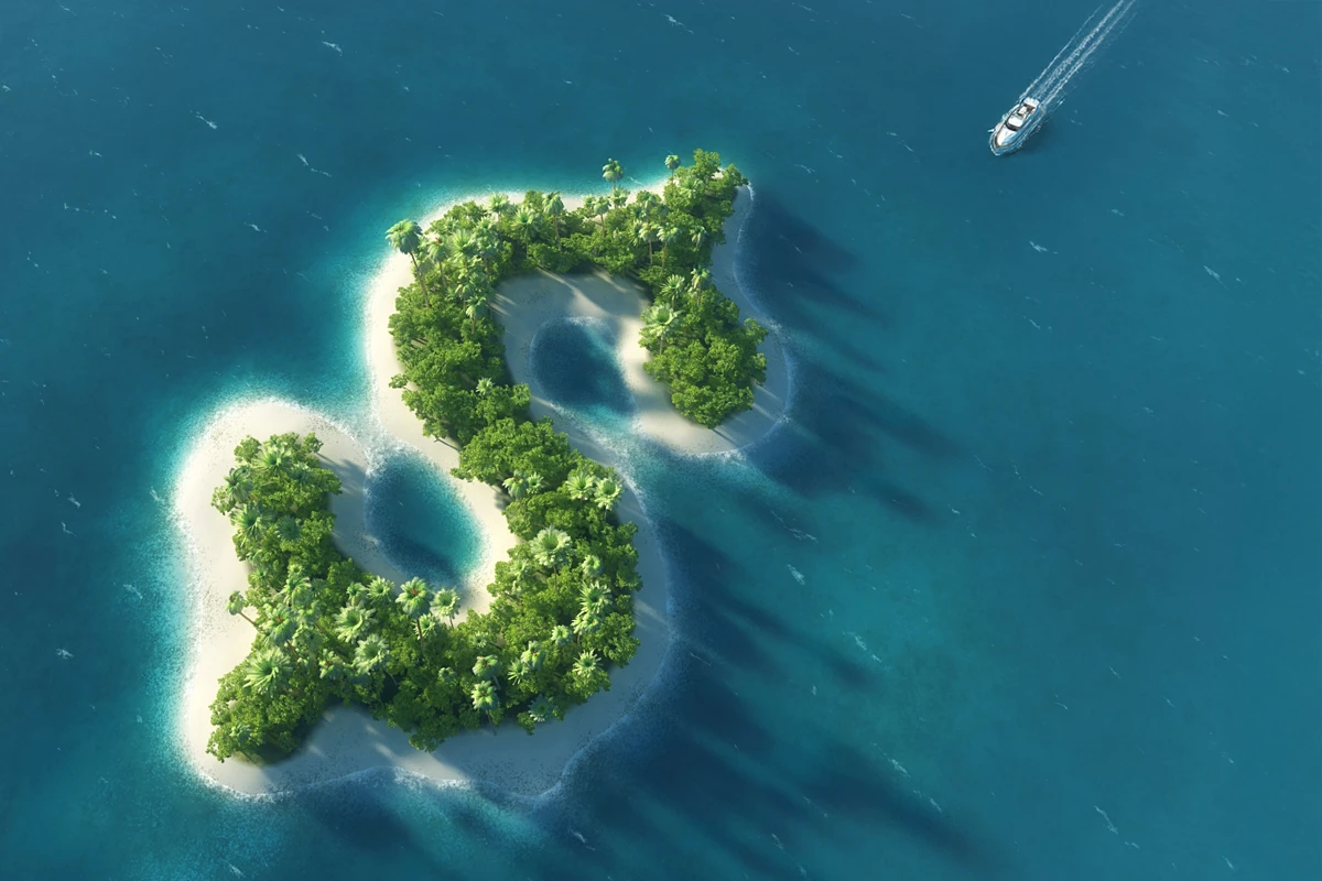 Aerial view of two lush, green islands surrounded by clear blue water and a boat in the distance.