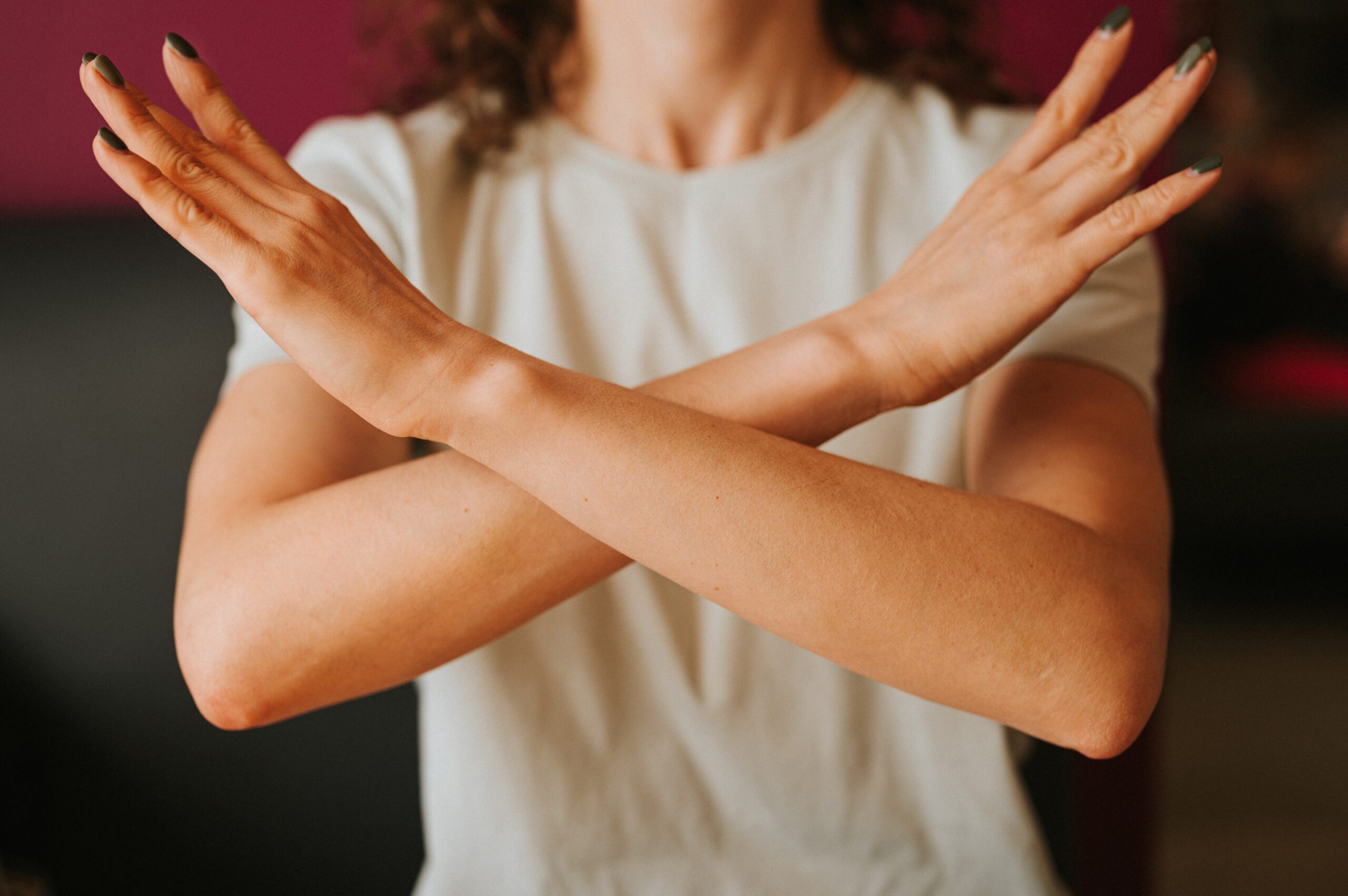 A person crosses their arms in front of them, conveying a gesture of refusal or disagreement. best salary negotiation strategies